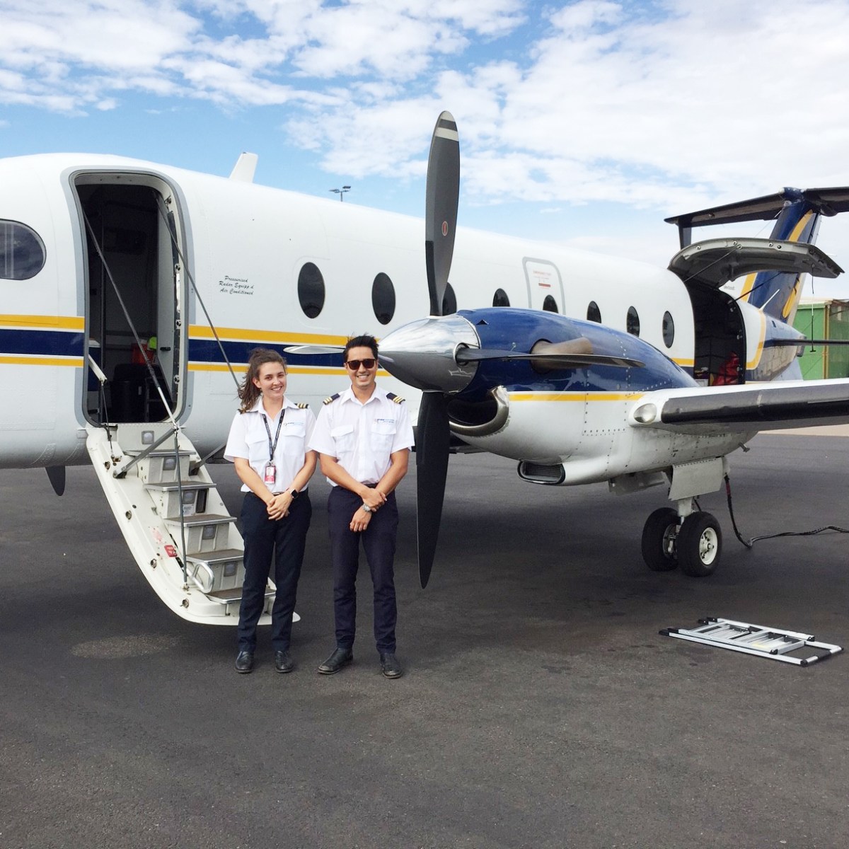 Two pilots standing behind the plane
