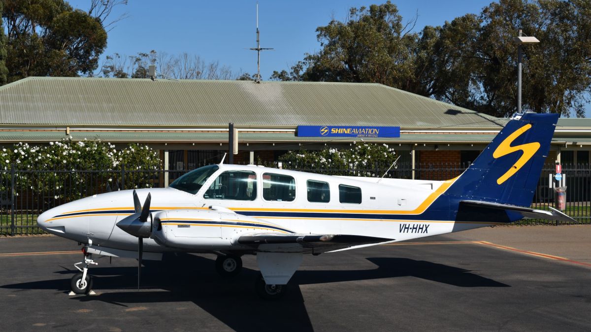 VH-HHX a small airplane is parked on the side of a road
