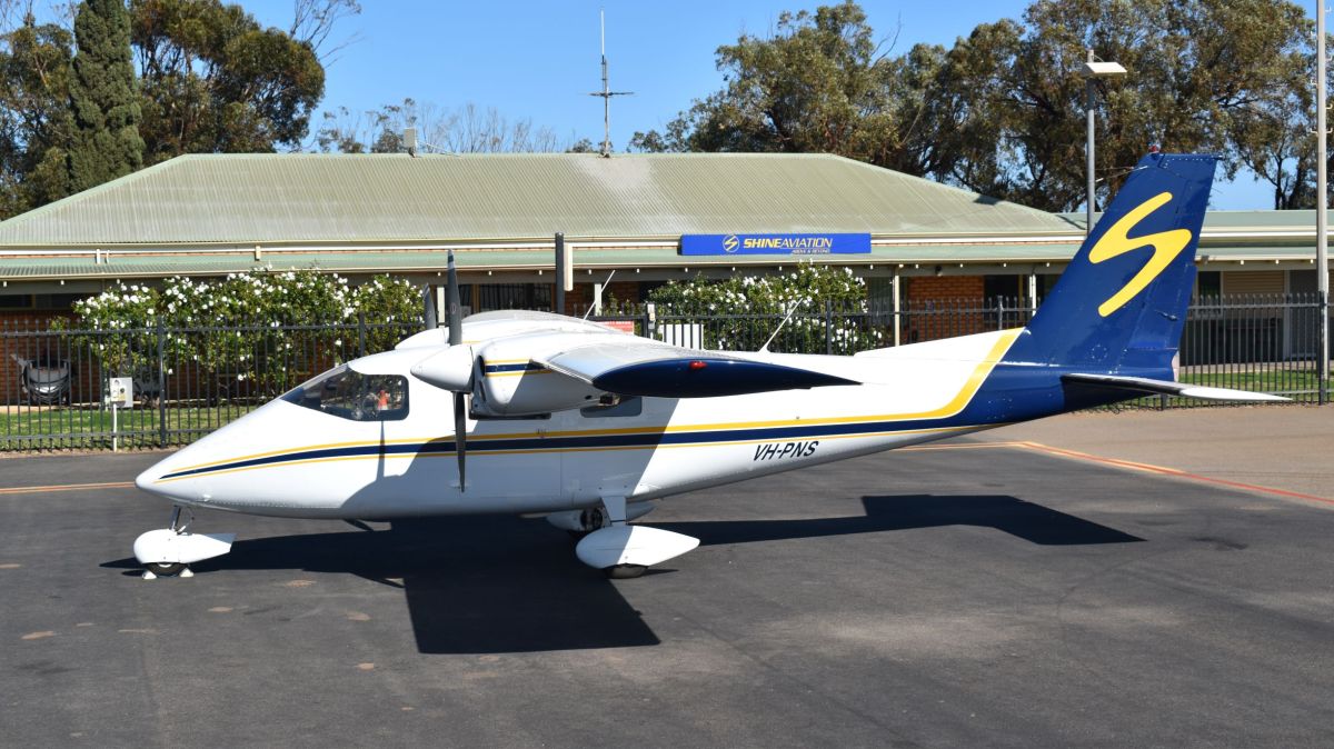VH-PNS a small plane parked on the side of a road